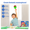 Boy holding a green and red craft creation with Ultimate Art & Craft Activity Chest on table