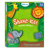 Front view of the Skillmatics “Shake-its! Amazing Animals” box with a green jungle background. Illustrated animal shake-it keychains include a giraffe, lion, and elephant filled with glitter confetti. The Skillmatics logo appears at the top, an age badge shows 4–9 years, and a blue callout reads “Make ’em, shake ’em, wear ’em.” A small choking hazard warning is visible at the bottom.