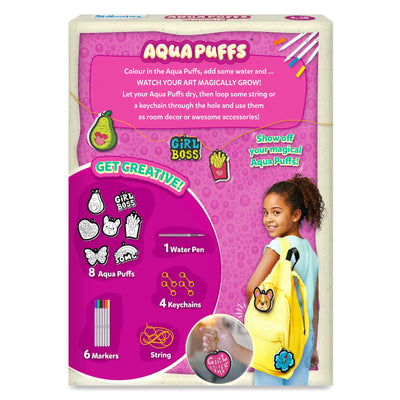 Back of Aqua Puffs Girl Power box featuring instructions to color, add water and let designs grow, then attach string or keychains. Shows 8 cutout shapes, 6 markers, 1 water pen, 4 keychains and string. Lifestyle image displays child wearing backpack with attached designs. Text highlights creativity and room décor use.