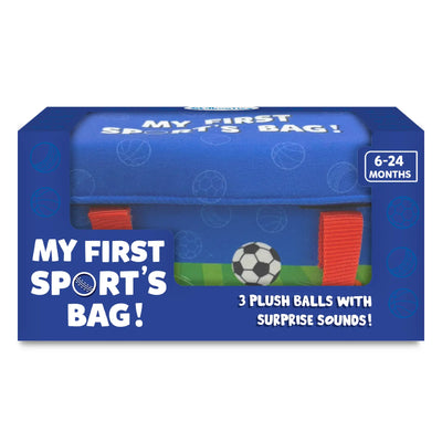 Front-facing view of Skillmatics “My First Sport’s Bag!” retail box in blue packaging with sports-themed graphics. A clear window reveals the blue fabric bag inside with red carry handles. Text on the box reads “3 plush balls with surprise sounds,” and an age badge on the top right indicates suitability for 6–24 months.
