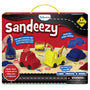 The Sandeezy skill-building kit box shows a red background with the Skillmatics logo, “Sandeezy” in bold letters, and a “3–7 years” badge. The display features kinetic sand in red, yellow, and blue jars, three moulded vehicle shapes, and sample creations including a fire engine, crane, and car with wheels. Callouts highlight “Create 10+ unique vehicles,” “Super sand that sticks,” and “Squish, shape, and mould without drying out.”