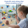 A child stands near a glass window placing colorful static stickers on the surface. Text at the top reads “Create 40+ static stickers that cling to any glossy surface!” Stickers include vehicles, musical instruments, sports items, and dinosaurs. The image shows hands pressing stickers onto glass, demonstrating residue-free, reusable play in a bright indoor setting.