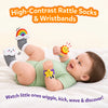 Baby lying on a soft white bed wearing Skillmatics Wriggle & Wonder high-contrast socks and wristbands, smiling while kicking and moving. Rainbow, cloud, sun and star designs support visual and sensory discovery, with the heading “High-Contrast Rattle Socks & Wristbands.”