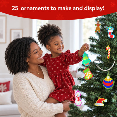 A child and parent decorating a Christmas tree together using Skillmatics Foil Fun ornaments. The child smiles while hanging colourful handmade foil decorations, including stars, stockings, snowmen and baubles, creating a festive family activity scene in a bright home setting.