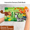 A little hand holding the interactive cloth book 'Whose Tail is That?' open, with the pages showing animal tails. One page features a monkey tail, and the other displays a zebra's striped tail. The soft, sensory-friendly tails are part of the engaging design, and the little hand is actively touching the tails, promoting fine motor skills development.
