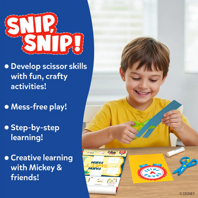 A young child sitting at a table smiles while using green safety scissors to cut a blue paper strip from the Snip Snip activity set. Open activity pages with Disney characters lie on the table alongside a glue stick and an extra pair of scissors. A blue panel lists features such as developing scissor skills, mess-free play, step-by-step learning, and creative activities with Mickey and friends.