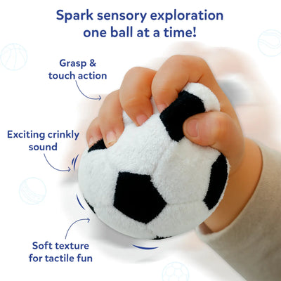 Close-up of a baby’s hand squeezing a soft black-and-white plush soccer ball. Text and arrows highlight sensory features including “Grasp & touch action,” “Exciting crinkly sound,” and “Soft texture for tactile fun.” The image focuses on hand grip, fabric texture, and compression, emphasizing tactile exploration and sensory engagement through touch and sound.