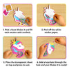 A four-panel instructional layout shows hands assembling a unicorn foam shake-it on a wooden surface. Steps include filling sections with colorful confetti, peeling off white backing paper, placing a transparent sheet to seal the foam shape, and attaching a keychain loop through the top hole. Each step is numbered and framed against a purple background for clear visual guidance.