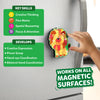 A decorated foil lion magnet is attached to a silver refrigerator as a child’s hand reaches to adjust it. On the left, two green skill panels list creative thinking, fine motor, spatial reasoning, and focus and attention, along with developmental benefits like creative expression, pincer grasp, hand-eye coordination, and bilateral coordination. A bold label at the bottom reads “Works on all magnetic surfaces!”