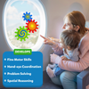 A mother and baby sit beside an airplane window playing with Skillmatics Spinny Gears Pattern Pop toy. Three colourful suction gears—green, blue, and red—are attached to the window. The child reaches out excitedly while the text highlights “Develops Fine Motor Skills, Hand-eye Coordination, Problem Solving, and Spatial Reasoning.” A travel-friendly STEM toy for engaging toddler play.