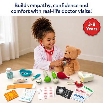 Young child dressed as a doctor uses a toy stethoscope to examine a teddy bear while seated at a table with Skillmatics Doctor Set accessories. Visible items include a thermometer, syringe, pulse oximeter, medicine bottle, blood pressure monitor, X-ray sheets, bandages, stickers, and prescription pad.
