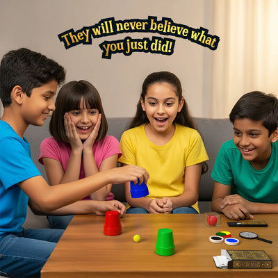 A group of four children engaged in a magic trick, with excitement on their faces. One child is holding a blue cup, performing the classic cup and ball trick from the Skillmatics Classic Magic Kit. The children, dressed in colourful t-shirts, are amazed as they watch the trick unfold. The background is simple and cozy, emphasizing the fun and excitement of learning magic tricks with friends and family.
