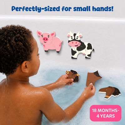 A young child plays in a bubble-filled bathtub while assembling soft foam farm animal puzzles. Completed pig and cow puzzles stick to the wet bath wall, while horse puzzle pieces are held in both hands. The image highlights perfectly sized pieces for small hands and suitability for ages 18 months to 4 years