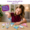 A smiling child sits at a table pouring blue confetti from a small packet into a unicorn-shaped foam shake-it. On the tabletop are additional foam shapes, transparent sheets, keychain loops, and multiple confetti packs in pink, gold, and multicolor. A purple badge reads “Make ’em, shake ’em, wear ’em,” while text above says “Fill your keychains with the coolest kinds of confetti.”