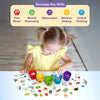 Top-down view of a child wearing a yellow dress carefully placing picture pieces into five vowel cups labeled a, e, i, o, and u. A banner at the top reads “Develops Key Skills” with icons representing fine motor skills, mental processing, observation, decision making, and critical thinking. The table is filled with illustrated tokens, showing focus, coordination, and early cognitive skill development.