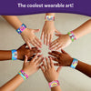 Children’s hands wearing colorful decorative slap bracelets from Snap Bandz Unicorns and Princesses