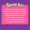 A purple background features a large pink rounded rectangle bordered with glitter and topped by the “Shake-its!” logo in white and gold. White text explains the activity, describing filling unicorn and princess shapes with sparkly beads and colorful confetti, sealing them, adding keychains, and shaking them to watch the confetti swirl. Subtle star sparkles appear around the panel.