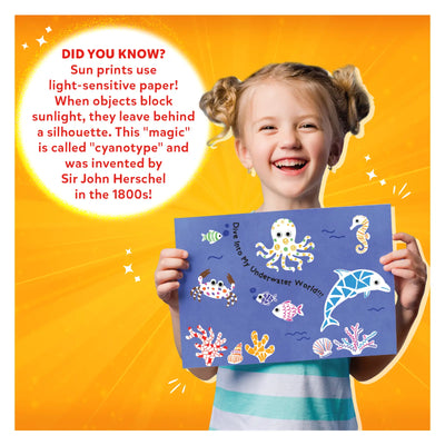 Young girl holding blue sun print with sea creatures from Magical Sun Art Kit