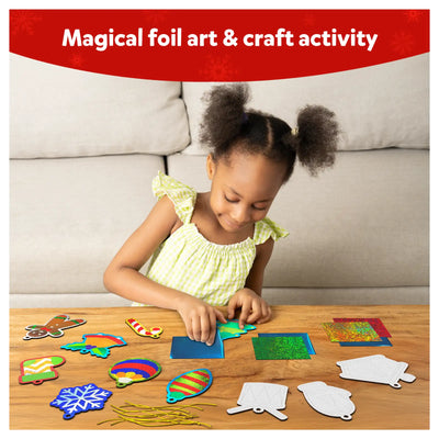 Child creating colorful holiday-themed foil art on Christmas ornament shapes with Foil Fun kit