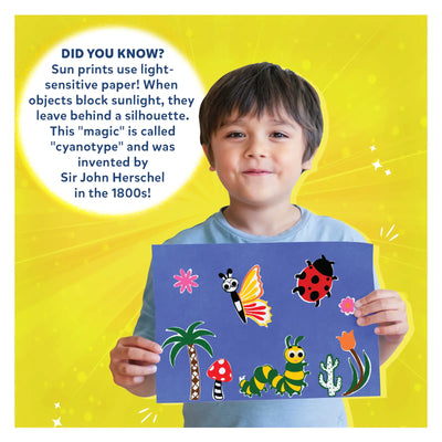 Young boy proudly displaying colorful cyanotype art with Sun Paper Art Kit in nature