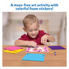 Young boy happily creating art with colorful foam puppy stickers from Fun with Foam product