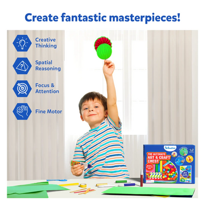 Boy holding a green and red craft creation with Ultimate Art & Craft Activity Chest on table